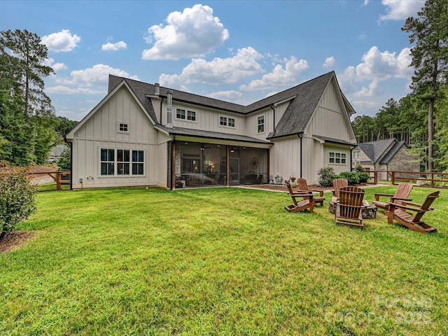 back of house with a fire pit, a lawn, and a sunroom