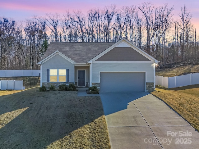 view of front of house with driveway, a shingled roof, stone siding, an attached garage, and fence