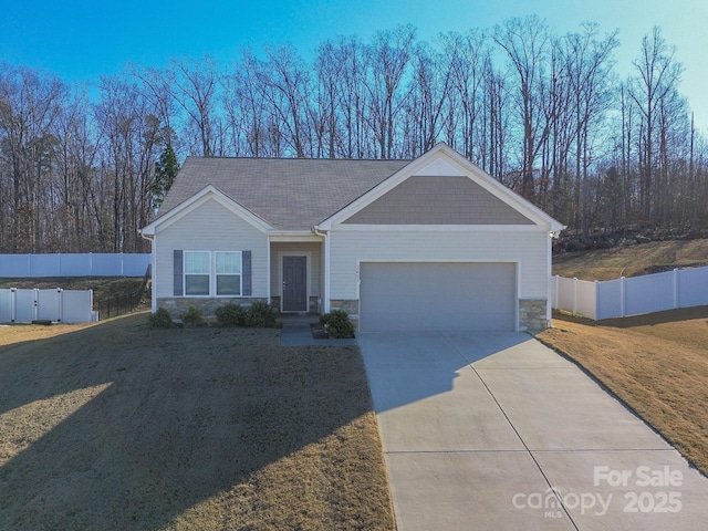 view of front of home featuring stone siding, fence, and an attached garage