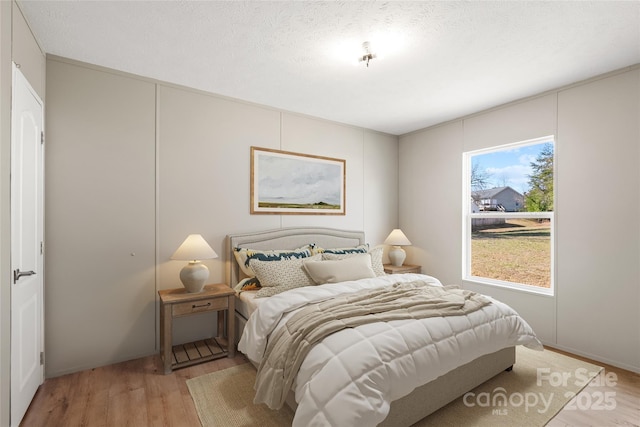 bedroom featuring a textured ceiling and light wood-type flooring