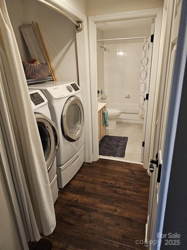 laundry area featuring washer and dryer and dark hardwood / wood-style flooring