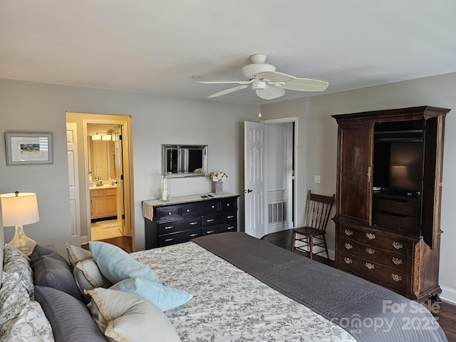 bedroom featuring dark hardwood / wood-style flooring, sink, ensuite bath, and ceiling fan