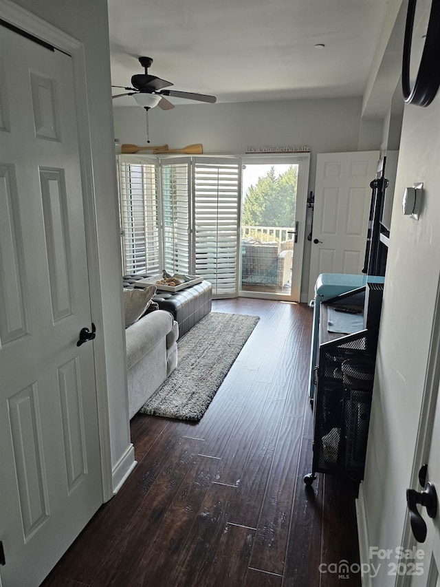 living room with dark wood-type flooring and ceiling fan