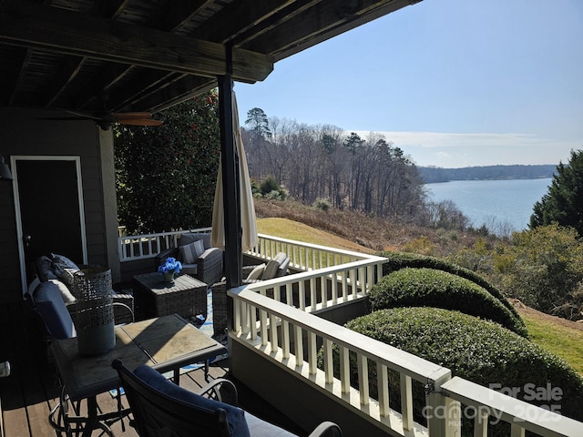 deck with a water view and ceiling fan