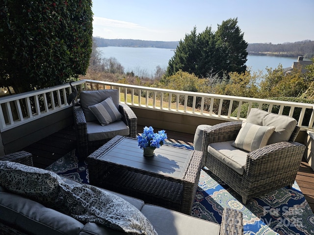 wooden terrace featuring an outdoor living space and a water view