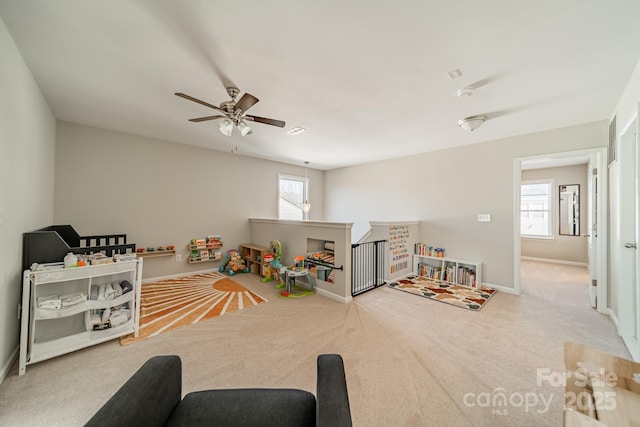 rec room featuring ceiling fan, baseboards, and light colored carpet