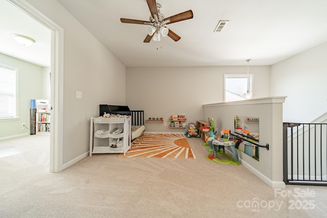 rec room featuring light carpet, baseboards, visible vents, and a ceiling fan