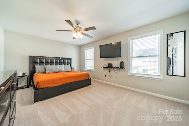 bedroom with light carpet, a ceiling fan, and baseboards