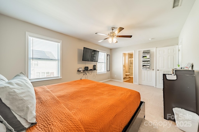 bedroom with connected bathroom, light colored carpet, a ceiling fan, baseboards, and visible vents