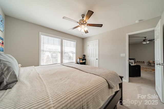 bedroom featuring a ceiling fan, light carpet, and baseboards