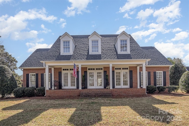 cape cod home with a front lawn and french doors