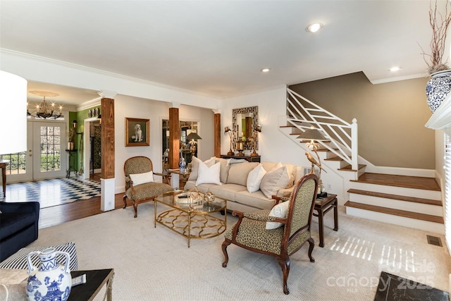 living room with crown molding, hardwood / wood-style floors, a notable chandelier, french doors, and ornate columns