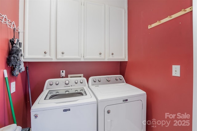 clothes washing area with cabinets and washing machine and dryer