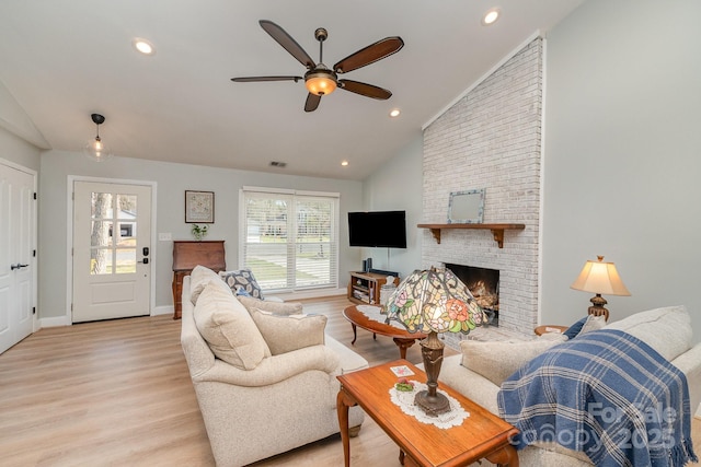 living room with baseboards, recessed lighting, light wood-style floors, and a fireplace