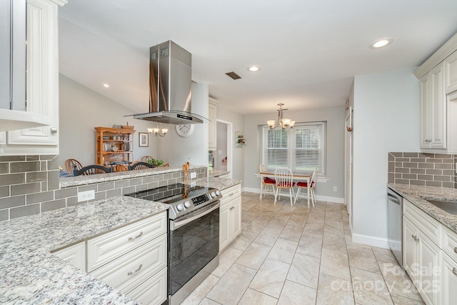 kitchen with light stone countertops, appliances with stainless steel finishes, pendant lighting, island exhaust hood, and a notable chandelier