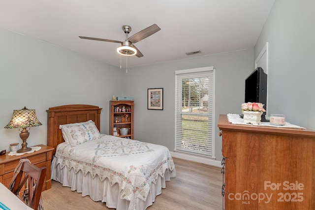 bedroom featuring ceiling fan, visible vents, and light wood-style flooring