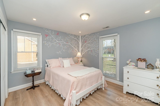 bedroom with light wood finished floors, baseboards, and visible vents