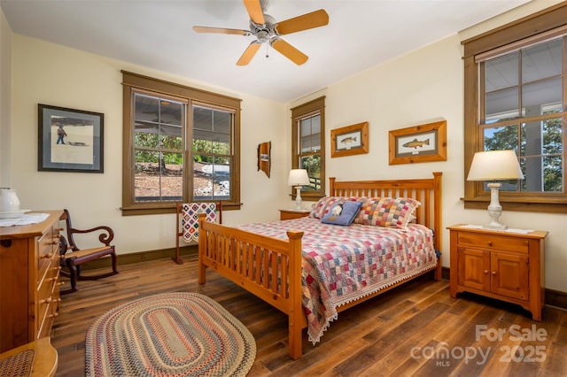 bedroom featuring multiple windows, dark wood-type flooring, and ceiling fan