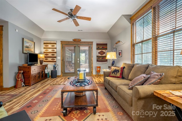 living room with light hardwood / wood-style floors, ceiling fan, and french doors