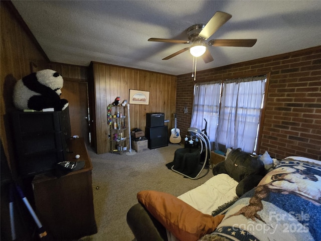 bedroom featuring ceiling fan, brick wall, carpet flooring, and a textured ceiling