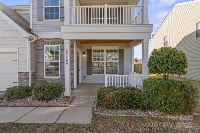 entrance to property featuring a porch and a balcony