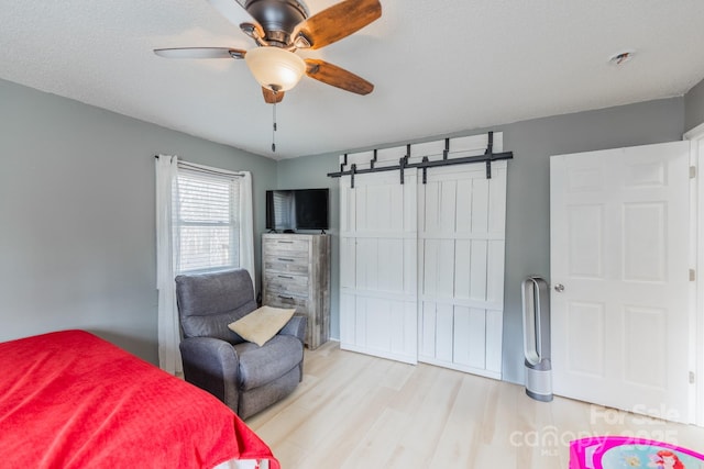 bedroom with a ceiling fan and light wood-style floors