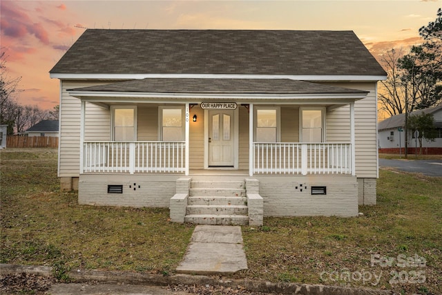 bungalow featuring covered porch and roof with shingles