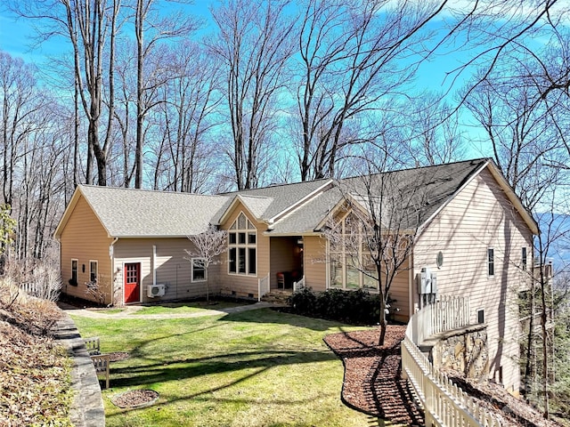 view of front of house featuring a front lawn and a shingled roof