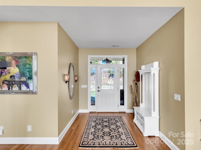 entryway featuring wood finished floors, visible vents, and baseboards