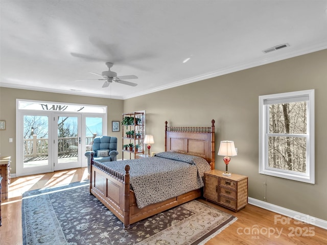 bedroom with light wood finished floors, baseboards, visible vents, access to outside, and crown molding