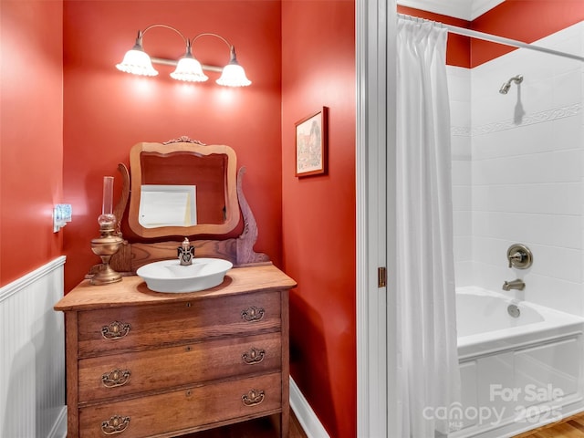 bathroom featuring a wainscoted wall, shower / tub combo, and vanity