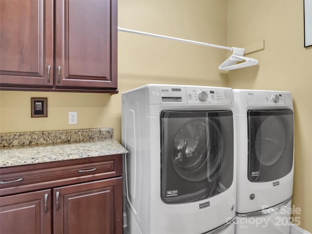 clothes washing area with cabinet space and washer and clothes dryer