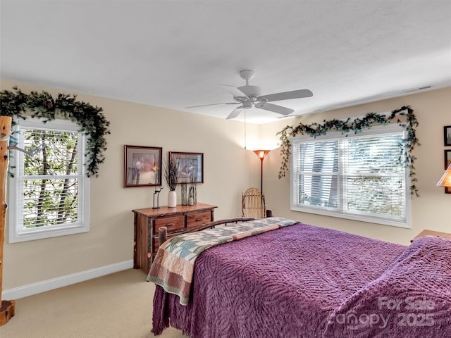 bedroom with ceiling fan, baseboards, and light colored carpet