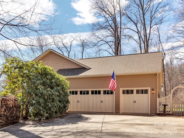 exterior space featuring roof with shingles and driveway