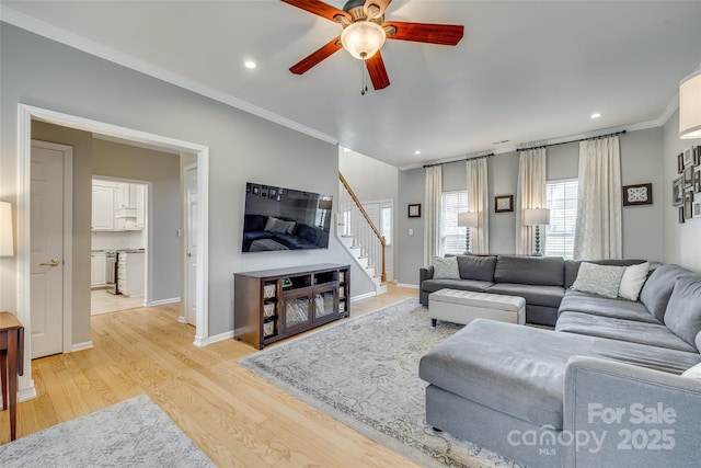 living room featuring light wood-type flooring, crown molding, and ceiling fan