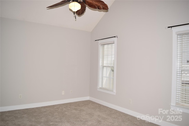 carpeted empty room featuring lofted ceiling, ceiling fan, and baseboards