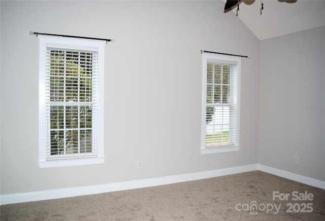 spare room with a ceiling fan, carpet flooring, vaulted ceiling, and baseboards