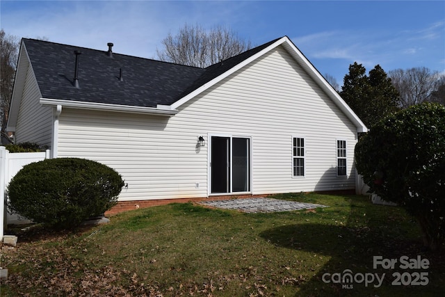 back of property featuring a shingled roof, a patio area, a yard, and fence