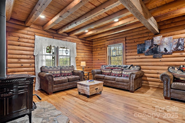 living area with wooden ceiling, log walls, beam ceiling, hardwood / wood-style floors, and a wood stove