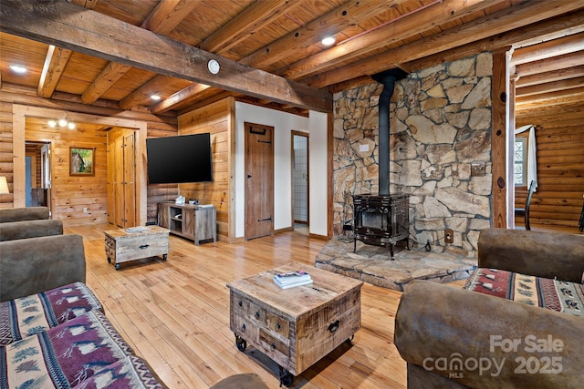 living area featuring wood-type flooring, wood ceiling, beamed ceiling, rustic walls, and a wood stove