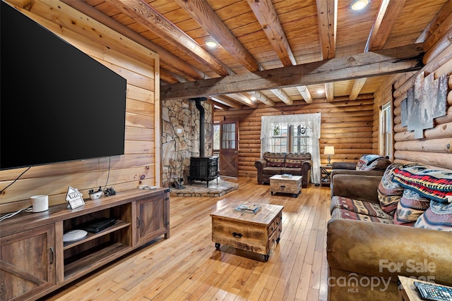 living room featuring wooden ceiling, light wood-type flooring, beam ceiling, log walls, and a wood stove