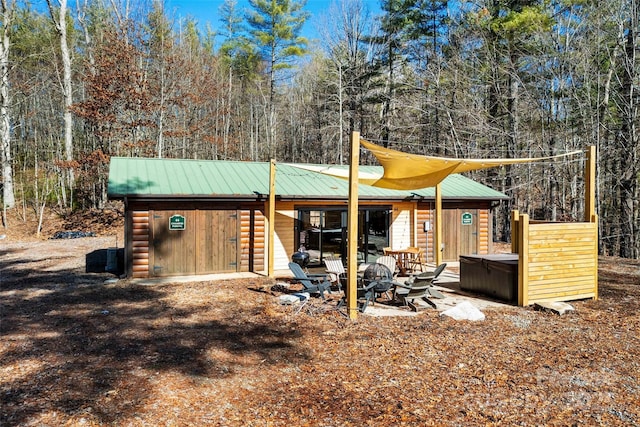 exterior space with an outdoor fire pit and a hot tub