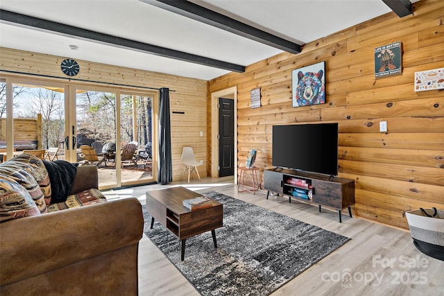 living room featuring wood walls, french doors, beam ceiling, and wood finished floors