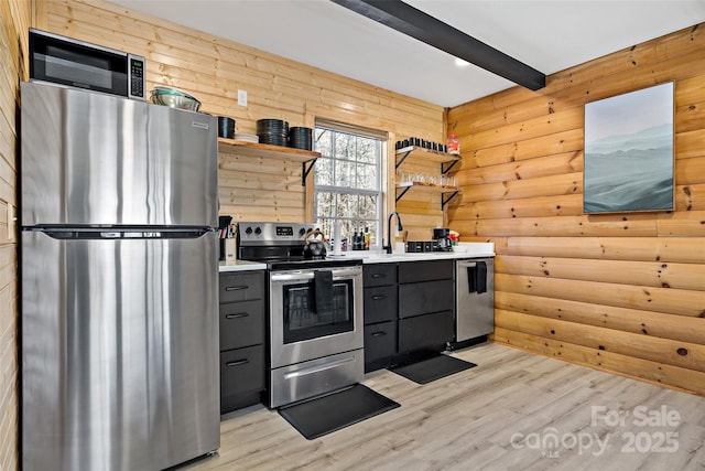 kitchen with appliances with stainless steel finishes, gray cabinetry, light wood-type flooring, open shelves, and beam ceiling