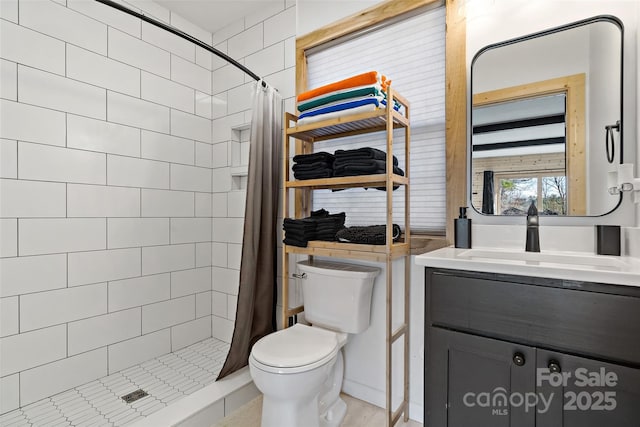 bathroom featuring a shower stall, toilet, and vanity