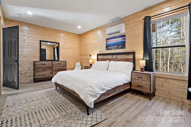 bedroom featuring recessed lighting, a wall unit AC, wood finished floors, and wooden walls