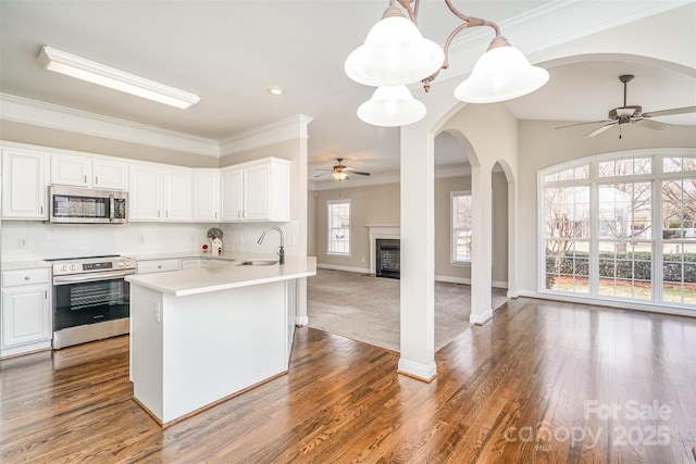 kitchen with open floor plan, stainless steel appliances, light countertops, and white cabinets