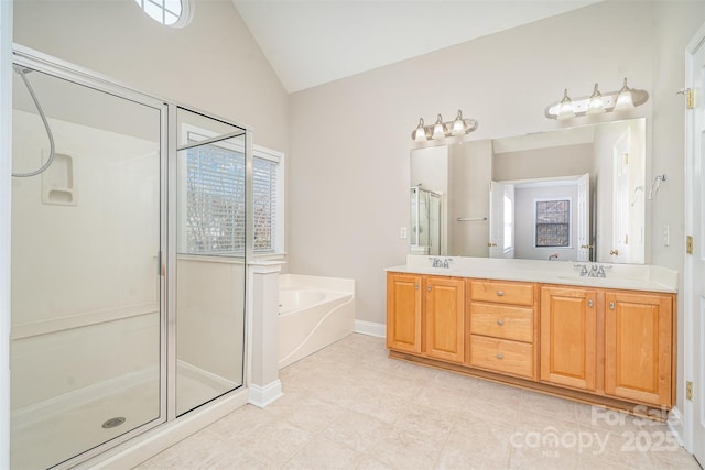 bathroom featuring lofted ceiling, a garden tub, a shower stall, and a sink