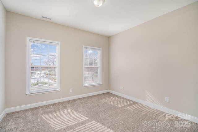 carpeted empty room with visible vents and baseboards