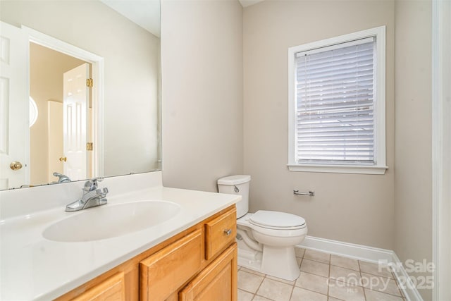 bathroom with toilet, tile patterned flooring, baseboards, and vanity